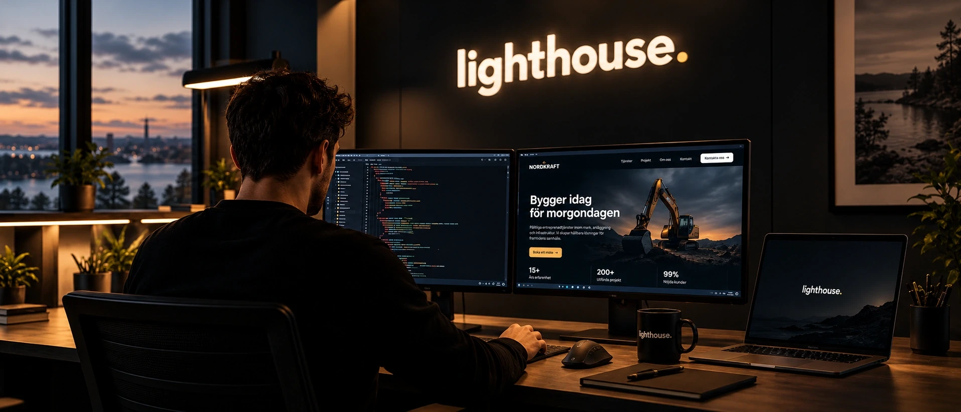 Utvecklare vid två skärmar under den upplysta Lighthouse-skylten
